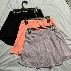 Three tennis skirts with pockets, pink purple and black